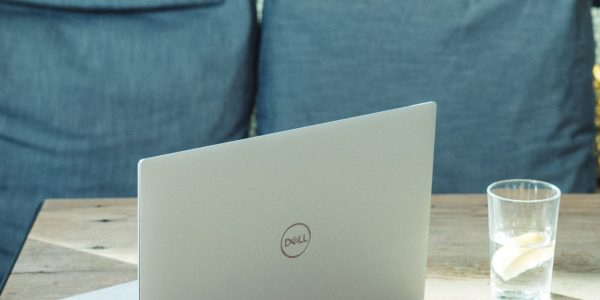 silver laptop on brown wooden table
