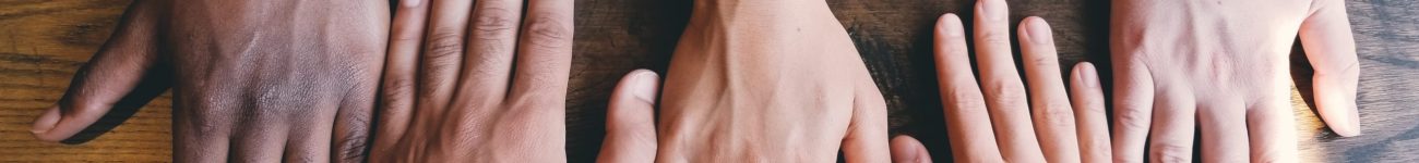 five human hands on brown surface